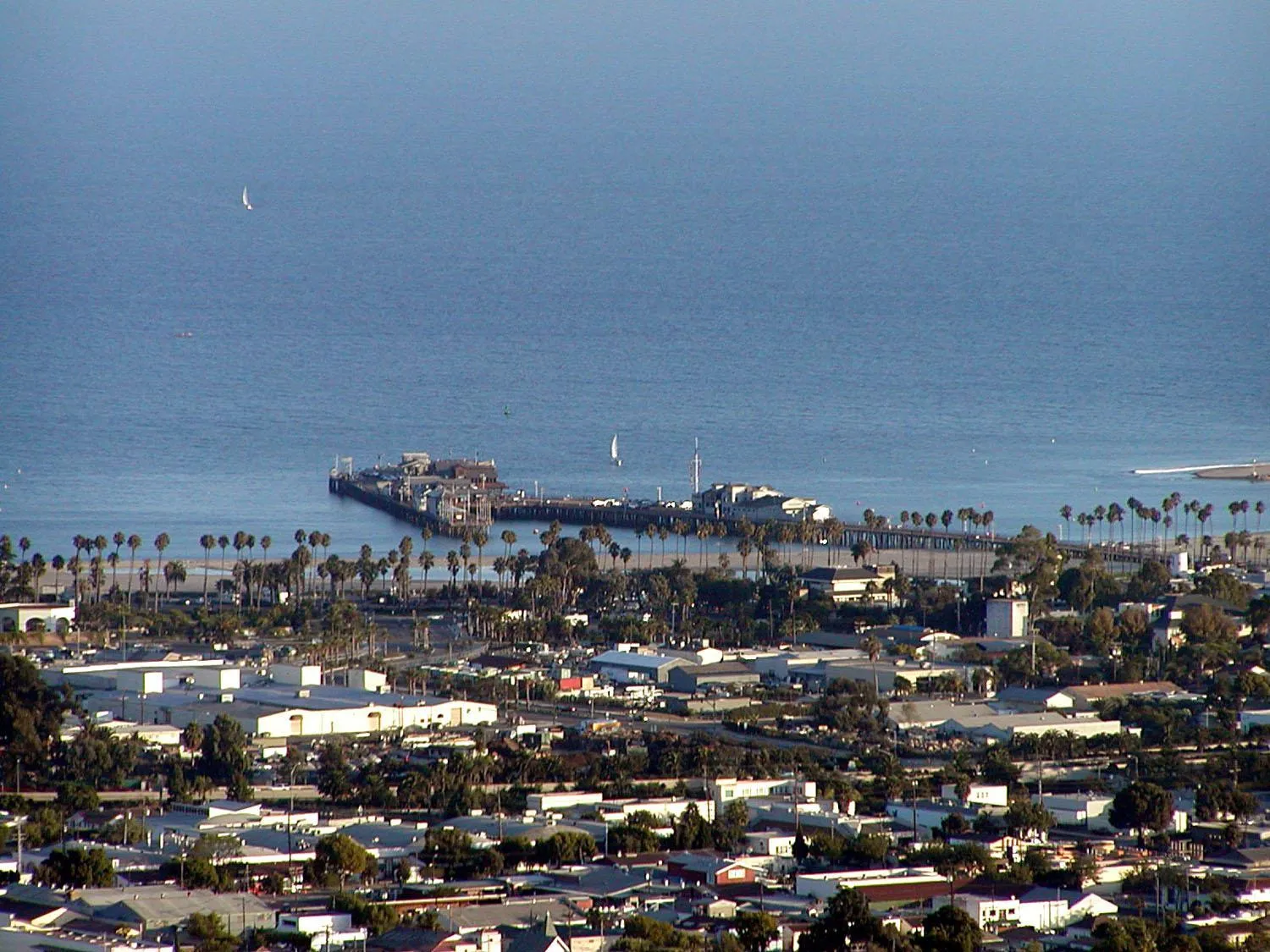 Aerial view of Santa Barbara with Stearns Wharf reaching into the Pacific and the mountains behind the city